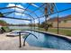 Beautiful screened-in pool overlooking a serene lake with a fountain feature and tiled deck at 5383 Creekside Trl, Sarasota, FL 34243