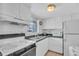 Kitchen with white cabinets, green countertops, and essential appliances at 5889 Canal Dr # I4, Bradenton, FL 34207