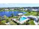 Gorgeous aerial view of a large pool, complemented by a tranquil lake and lush green spaces in a peaceful neighborhood at 6420 13Th Avenue W Dr, Bradenton, FL 34209