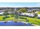 Panoramic aerial view showcasing lush landscaping, a tranquil pond, and single-story homes in a serene community at 6420 13Th Avenue W Dr, Bradenton, FL 34209