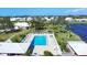 Scenic aerial view of a sparkling pool surrounded by well-manicured lawns, mature trees, and charming homes at 6420 13Th Avenue W Dr, Bradenton, FL 34209
