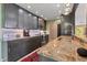 Modern kitchen with granite countertops, gray cabinets, and stainless steel appliances at 6420 13Th Avenue W Dr, Bradenton, FL 34209
