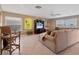 Spacious living room with neutral tones, a ceiling fan, and large windows at 6420 13Th Avenue W Dr, Bradenton, FL 34209