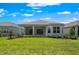 Expansive backyard featuring a well-maintained lawn and a home with a covered patio at 8024 Moonbeam Ave, Sarasota, FL 34241