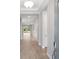 Bright hallway showcasing wood-look tile floors, recessed lighting, and access to various rooms at 8024 Moonbeam Ave, Sarasota, FL 34241