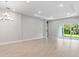 Bright living room with tiled floors, recessed lighting, and sliding glass doors to the outdoor area at 8024 Moonbeam Ave, Sarasota, FL 34241
