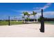 Sand volleyball court featuring a net, manicured sand, and surrounding green space for recreational play at 8109 Moonbeam Ave, Sarasota, FL 34241