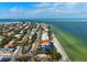 Aerial view of a blue beach house with a pool, situated on the shoreline with ocean views at 915 N Shore Dr, Anna Maria, FL 34216