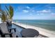 Breathtaking oceanfront balcony view with outdoor seating and a privacy screen at 915 N Shore Dr, Anna Maria, FL 34216