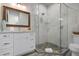 Modern bathroom features a vanity with white countertop, a mirror and a glass enclosed shower at 915 N Shore Dr, Anna Maria, FL 34216
