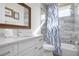 Modern bathroom features a large vanity, mirror, shower-tub combo, and tile flooring at 915 N Shore Dr, Anna Maria, FL 34216