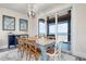 Bright dining room with elegant chandelier, ocean views, and a rustic wood table perfect for Gathering meals at 915 N Shore Dr, Anna Maria, FL 34216
