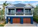 Two-story blue beach house with front-facing balconies and a charming mermaid decoration at 915 N Shore Dr, Anna Maria, FL 34216