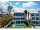 Multi-story home with multiple balconies, a pool and hot tub, and manicured lawn by the beach at 915 N Shore Dr, Anna Maria, FL 34216