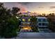 Stunning exterior view of a modern home with a private pool and beach access at sunset at 915 N Shore Dr, Anna Maria, FL 34216