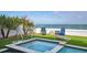 Inviting hot tub with ocean views, complemented by lush greenery and cozy outdoor seating at 915 N Shore Dr, Anna Maria, FL 34216