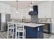 Spacious kitchen with white cabinets, dark blue island, stainless steel appliances, and stylish backsplash at 915 N Shore Dr, Anna Maria, FL 34216