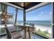 Relaxing covered patio with ocean views, comfortable seating, and a casual dining area for outdoor enjoyment at 915 N Shore Dr, Anna Maria, FL 34216