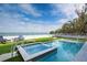 Stunning pool and spa with a clear view of the ocean and meticulously maintained lawn at 915 N Shore Dr, Anna Maria, FL 34216