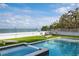 Beautiful pool and spa area with a well-manicured lawn and a scenic ocean view at 915 N Shore Dr, Anna Maria, FL 34216
