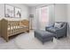 Cozy Bedroom with a crib, gray armchair, and soft neutral accents at 1342 Shaker Ln, North Port, FL 34286