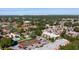 Aerial view showcasing community condos, pool, and lush trees, with a city skyline in the distance at 3201 Beneva Rd # 204, Sarasota, FL 34232