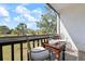 Balcony featuring a table and seating overlooking a lush green landscape under a blue sky at 3201 Beneva Rd # 204, Sarasota, FL 34232