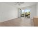 Bright bedroom features wood floors, ceiling fan, and sliding glass doors to outdoor balcony with seating at 3201 Beneva Rd # 204, Sarasota, FL 34232