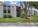 Exterior of condo building features a red tile roof, screened in porch, and lush landscaping at 3201 Beneva Rd # 204, Sarasota, FL 34232