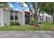 Exterior of condo building features a red tile roof, screened in porch, and lush landscaping at 3201 Beneva Rd # 204, Sarasota, FL 34232