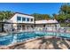 Community pool area with lounge chairs, pergola, pool house and clear blue water at 3201 Beneva Rd # 204, Sarasota, FL 34232