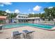 Community pool area with lounge chairs, pool house and clear blue water and patio at 3201 Beneva Rd # 204, Sarasota, FL 34232