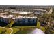Aerial view of a condominium complex near golf course and lake, showcasing its attractive location at 4570 Pinebrook Cir # 303, Bradenton, FL 34209