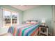 Bedroom features a window, colorful striped bedding, and a side table with a lamp at 4570 Pinebrook Cir # 303, Bradenton, FL 34209