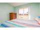 Bright bedroom features large window, colorful striped bedding, and wooden dresser at 4570 Pinebrook Cir # 303, Bradenton, FL 34209