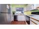 Modern kitchen with stainless steel appliances, white cabinetry, and a convenient pass-through to the living area at 4570 Pinebrook Cir # 303, Bradenton, FL 34209
