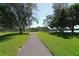 Scenic walking path amidst lush lawns and mature trees, ideal for a leisurely stroll at 4741 Independence Dr, Bradenton, FL 34210