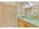 Bathroom featuring a glass block shower, wood vanity and wallpaper accents at 4914 Lakescene Pl, Sarasota, FL 34243