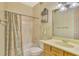 Charming bathroom with a shower-tub combo, featuring a light wood vanity and unique wallpaper design at 4914 Lakescene Pl, Sarasota, FL 34243