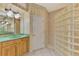 Bathroom featuring a glass block shower, wood vanity, and wallpaper accents at 4914 Lakescene Pl, Sarasota, FL 34243