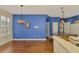 Dining room features wood floors, blue accent wall, and view of the kitchen at 4914 Lakescene Pl, Sarasota, FL 34243