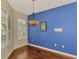 Dining space boasting hardwood floors, natural light, and vibrant blue accent wall at 4914 Lakescene Pl, Sarasota, FL 34243