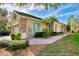 Exterior view of home showcasing stone accents, shutters, and tropical landscaping at 4914 Lakescene Pl, Sarasota, FL 34243