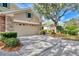 Two car garage with stone accents, shutters, and driveway at 4914 Lakescene Pl, Sarasota, FL 34243