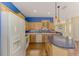 Bright kitchen with wood floors, island, stainless appliances, wood cabinets and blue accent wall at 4914 Lakescene Pl, Sarasota, FL 34243