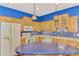 Bright kitchen features blue accent wall, tile backsplash, wood cabinetry, and a blue island at 4914 Lakescene Pl, Sarasota, FL 34243