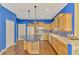 Bright kitchen features wood cabinets, blue accent wall, kitchen island, and tile backsplash at 4914 Lakescene Pl, Sarasota, FL 34243