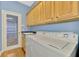 Well-equipped laundry room with ample cabinet space above the washer and dryer and a utility sink at 4914 Lakescene Pl, Sarasota, FL 34243