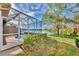 Outdoor space with a view of screened pool and spa area overlooking the lake and lush greenery at 4914 Lakescene Pl, Sarasota, FL 34243