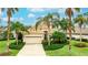 Charming single-story home featuring a two-car garage and lush tropical landscaping, set under a sunny sky at 7244 Orchid Island Pl, Bradenton, FL 34202